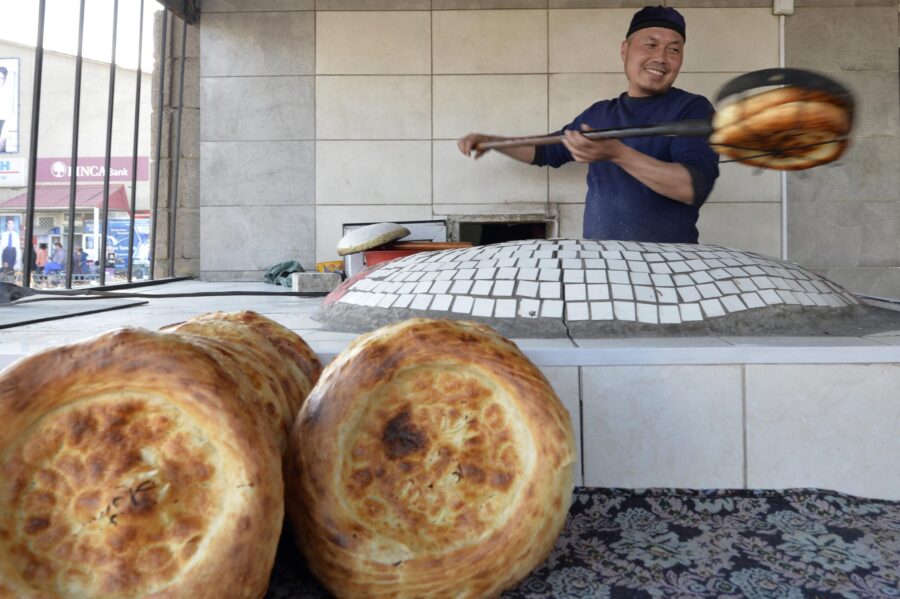 13 February 2018 - Bishkek, Kyrgyzstan - A Kyrgyz baker prepares a traditional bread 'Lepeshka' in a tandyr oven at the market in the village of Ivanovka, 50 km from Bishkek, Kyrgyzstan.